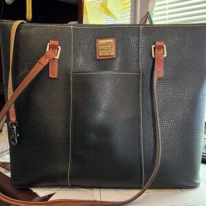 Dooney & Bourke black with brown trim, 100% leather outside. 100% cotton inside